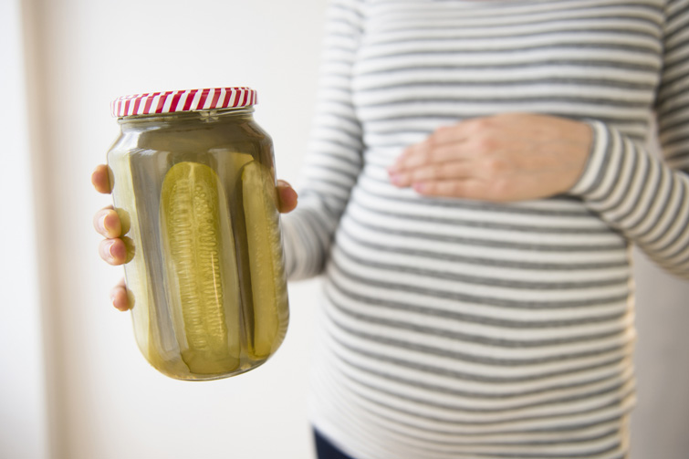 Pregnant lady holding gherkins in a jar