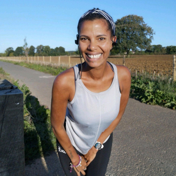 Ashli Sterling in running gear smiling on a rural path