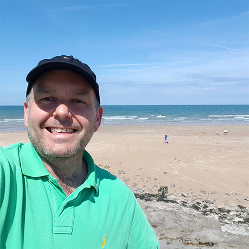 Andrew smiling in front of beach-summer activity ideas-slimming world blog