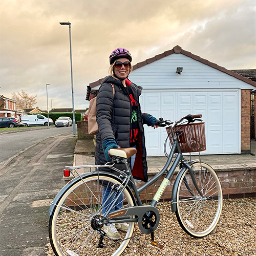 Slimming World member Amber standing outside holding a bicycle
