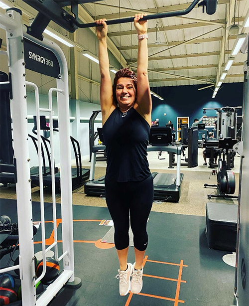 Slimming World member Jeanie hanging from monkey bars in a gym