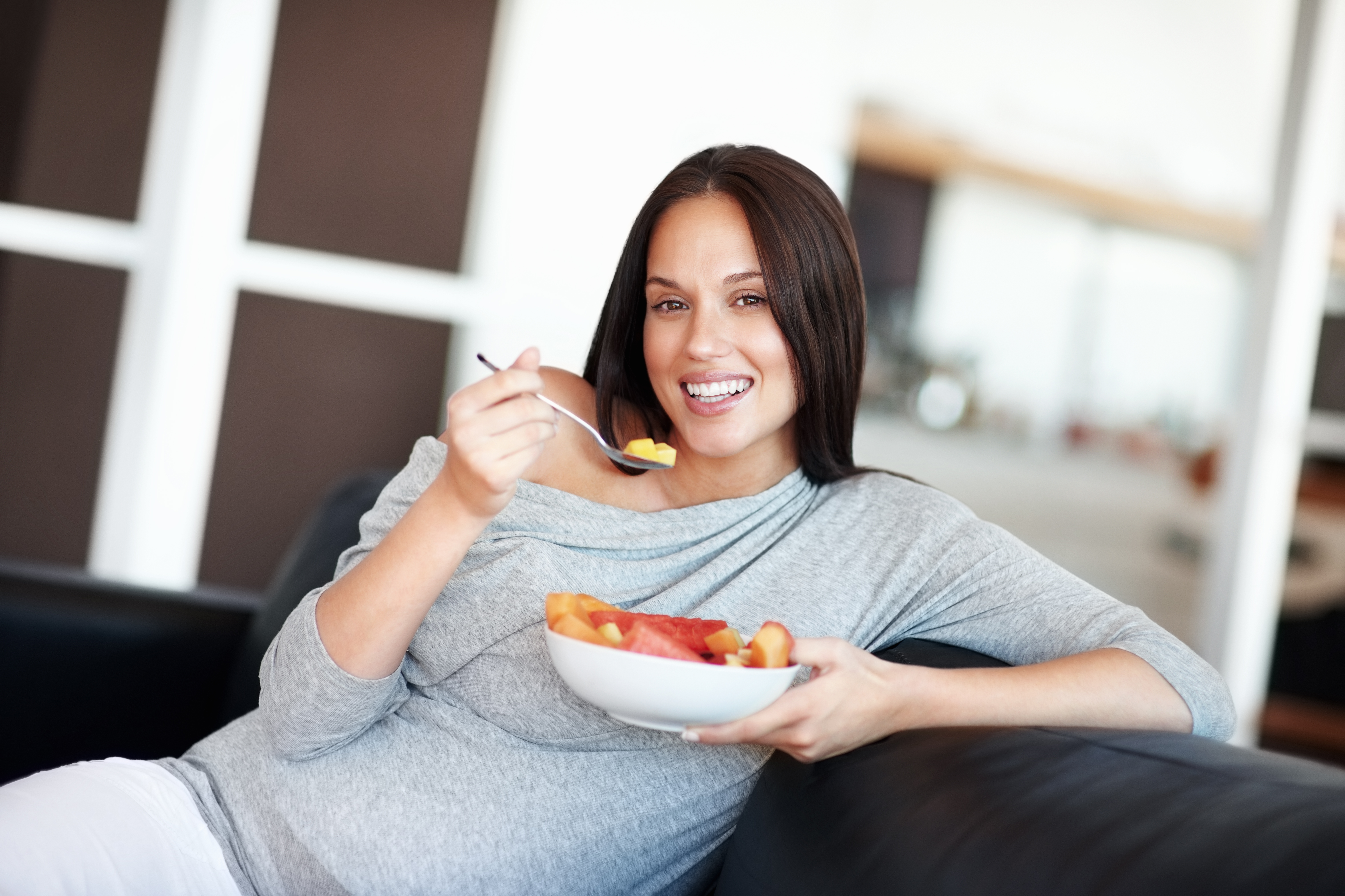 Pregnant woman eating a healthy fruit snack