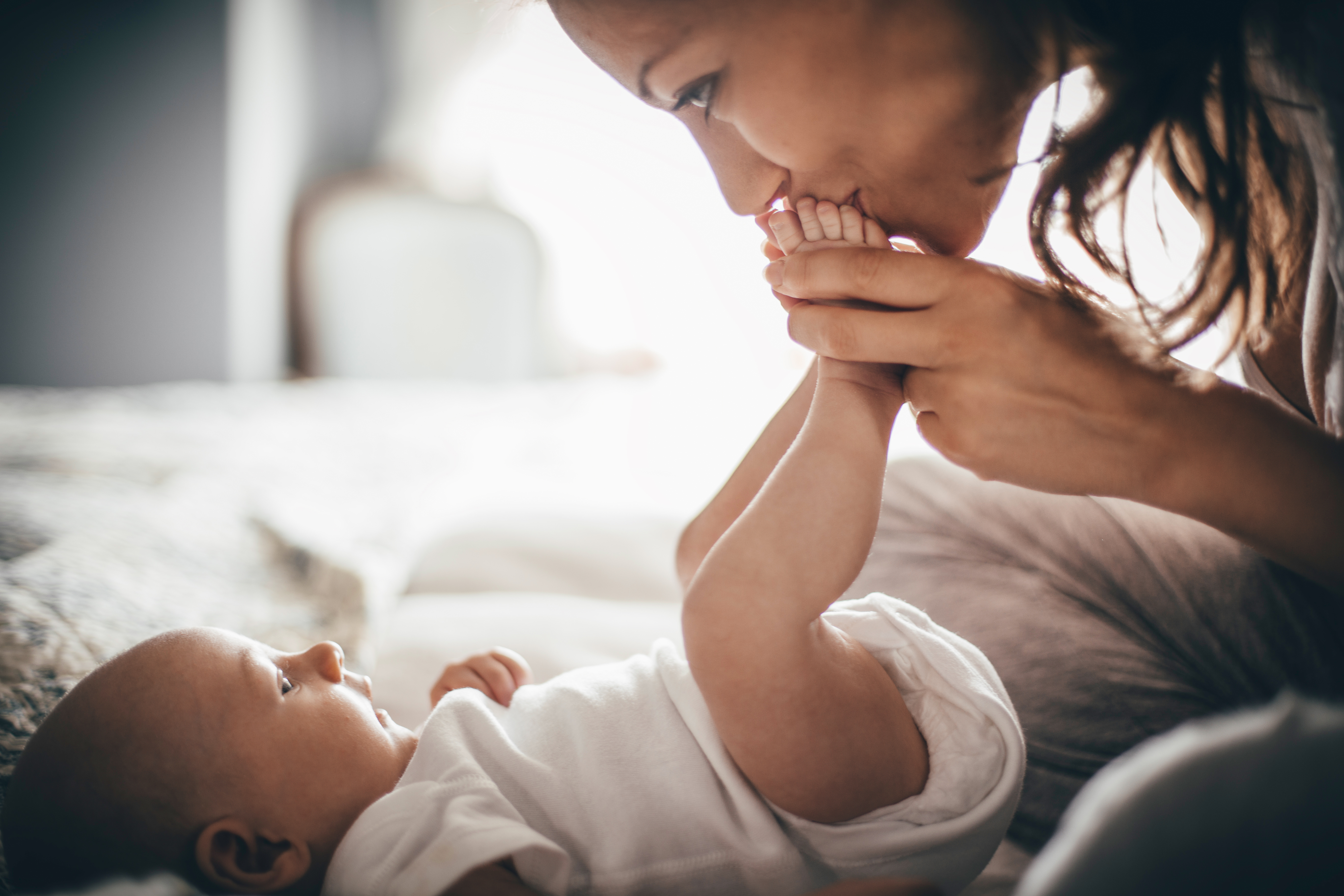 Mum kissing the feet of her baby