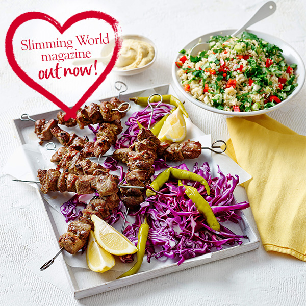 Lamb kebabs with couscous salad on silver baking tray with red heart logo reading 'Slimming World Magazine out now!'