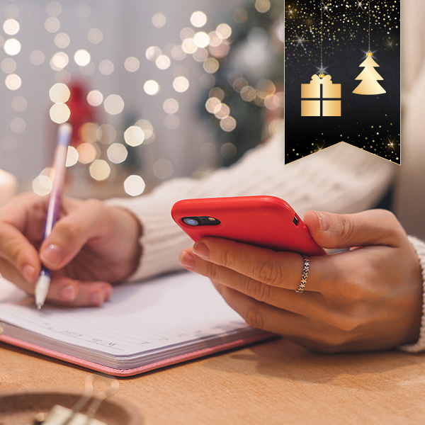 Slimming World member writing in notebook and scrolling through mobile phone