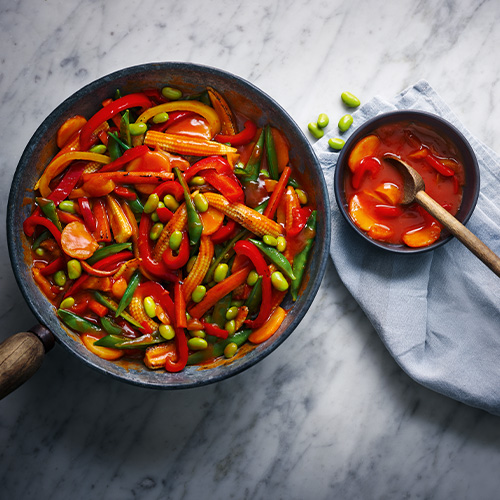 Slimming World sweet and sour sauce in a dark grey pot on a light grey background