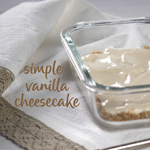 Vanilla Weetabix cheesecake in a glass container on a white cloth background