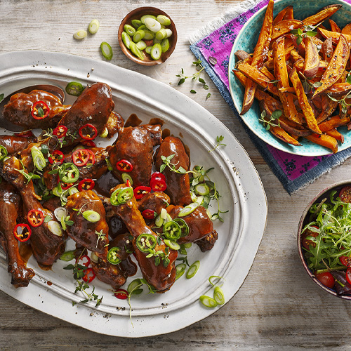 Sticky barbecue chicken drumsticks on a white serving dish