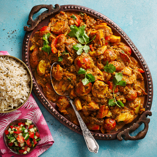 Slimming World roasted root vegetable curry on a bronze platter on a light blue background