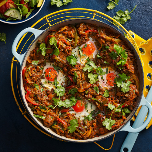 Slimming World spiced beef and sweet potato hash in a light blue plan on a dark blue background