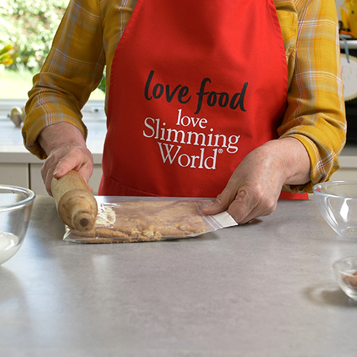 Slimming World chef bashing digestive biscuits with a rolling pin