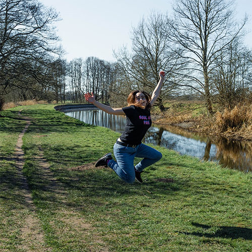 Slimming World Consultant Donna jumping in the air while walking in a park