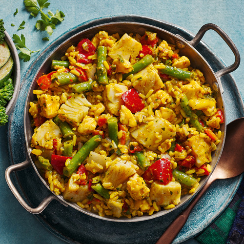 Slimming World smoked haddock kedgeree in a grey pot on a light blue background