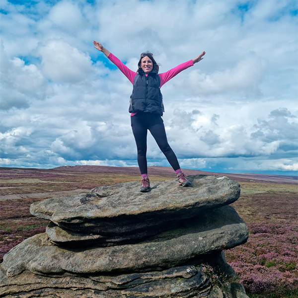 Slimming World member Danielle standing on a rock in the countryside