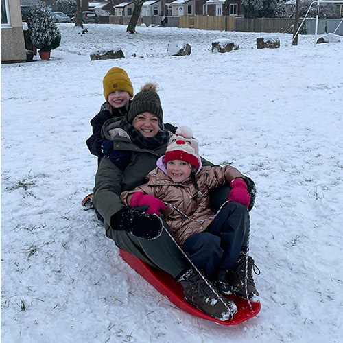 Jodie sitting in a sleigh with her daughter and niece