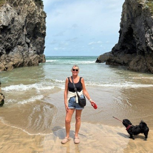 Slimming World member Sharon standing on a beach in Newquay with her dog