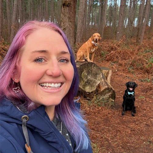 Woman walking with dogs in woods
