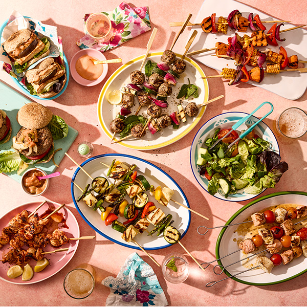 Spread of Slimming World barbecue food including burgers, veggie burgers and kebab skewers