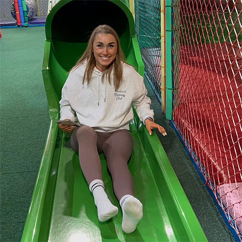 member Sascha Ross going down a slide